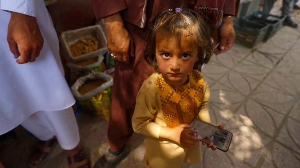 Girl with phone in Balkh bazaar