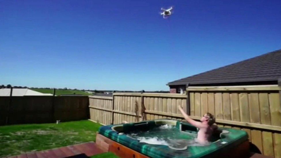 Man reaches for drone's load