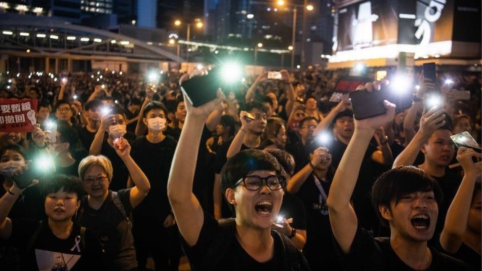 Protesters shine lights from their mobile phones during rally against a controversial extradition law proposal on 16 June 2019 in Hong Kong,