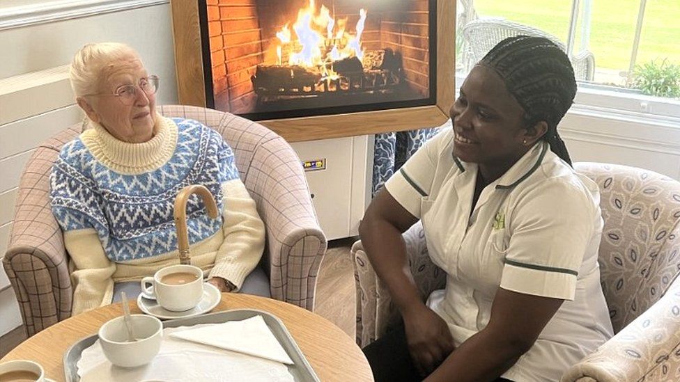 Ghanaian Harriet Mensah, 28, a nurse with Stow Healthcare based in Ford Place care home in Thetford, Norfolk. Sitting with resident Mary