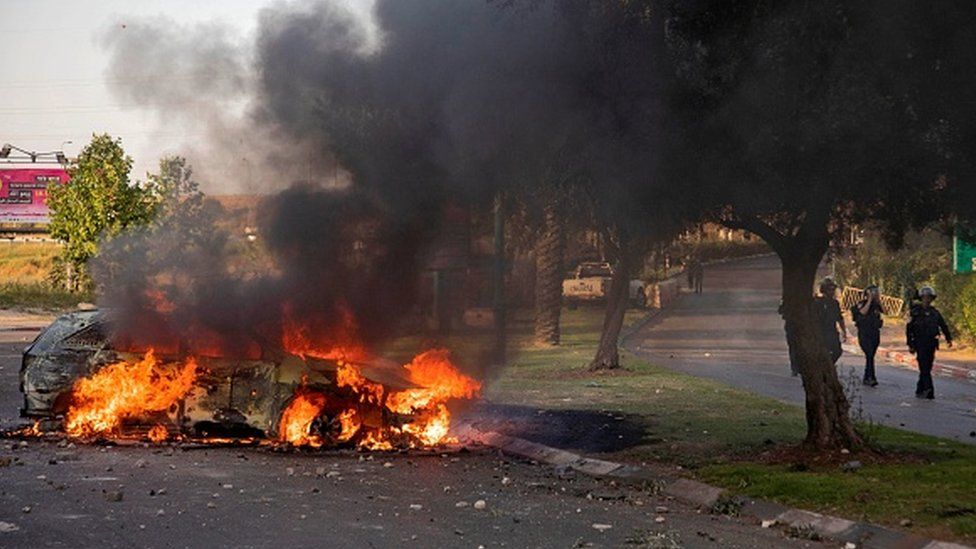 An Israeli police car burns after an Arab Israeli demonstration following a funeral in Lod near Tel Aviv