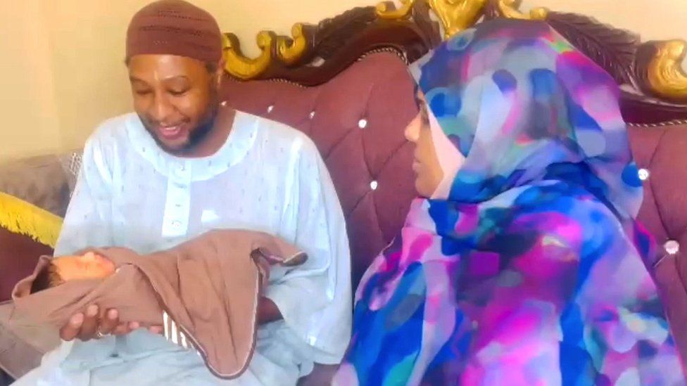 Bashayar al-Fadil sitting beside her husband as he holds their baby