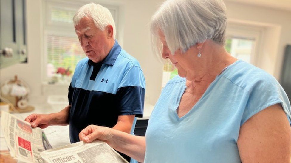 Catherine and Jeffrey looking though the press cuttings they have collected over the years