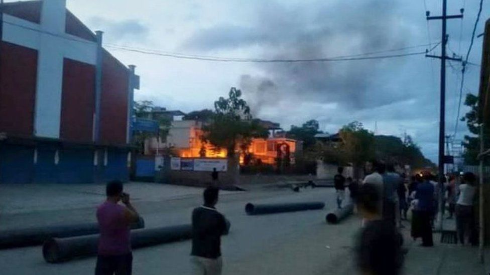 На этой фотографии, сделанной 31 августа 2015 г., индийцы наблюдают за пожаром в резиденции министра здравоохранения штата Манипур Фунгзапанга Тонсимга, которая была подожжена во время акции протеста против противоречивых законов о правах племен,