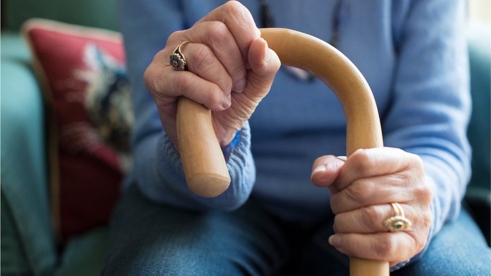 Stock photo of elderly woman gripping a cane