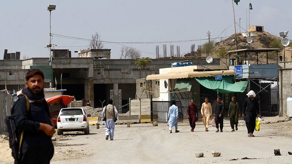 People wait by the key border crossing as trucks carrying goods destined for Afghanistan line up, following clashes between security forces of Pakistan and Afghanistan, in Torkham, Pakistan on September 07, 2023