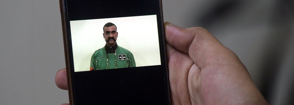 A Pakistani man watches the latest video statement released by Pakistan's military authorities of the Indian Wing Commander pilot Abhinandan Varthaman on his smartphone