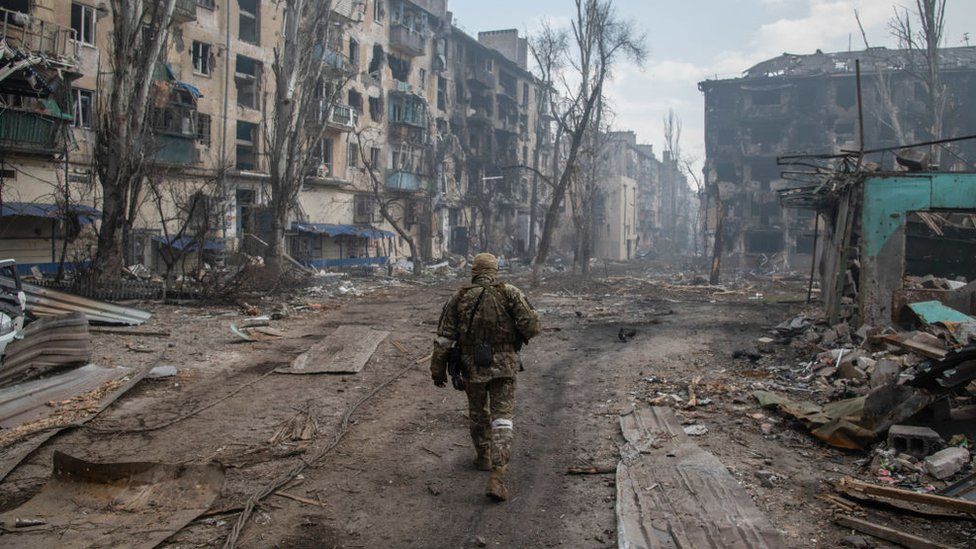 Российский солдат ходит по руинам Мариуполя в 2022 году