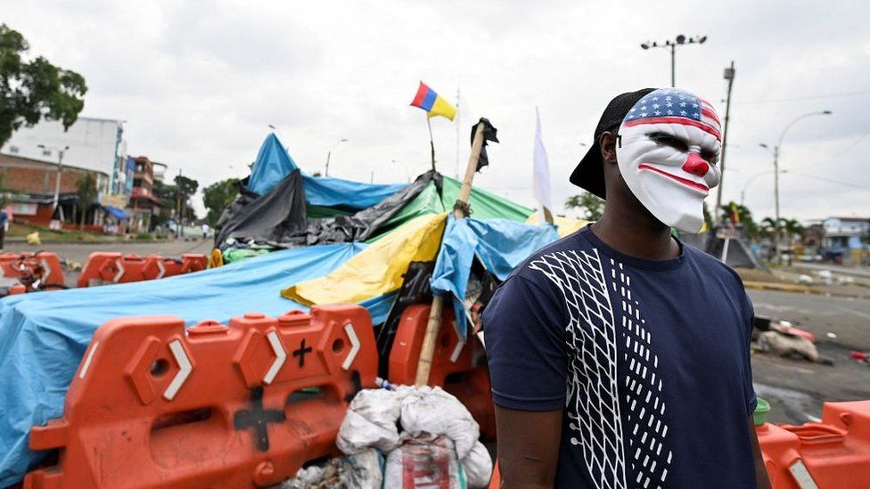 Демонстрант стоит рядом с баррикадой во время акции протеста против правительства президента Колумбии Ивана Дуке в Кали, 29 мая 2021 г.