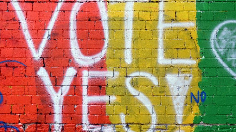A message on a wall says "VOTE YES!"