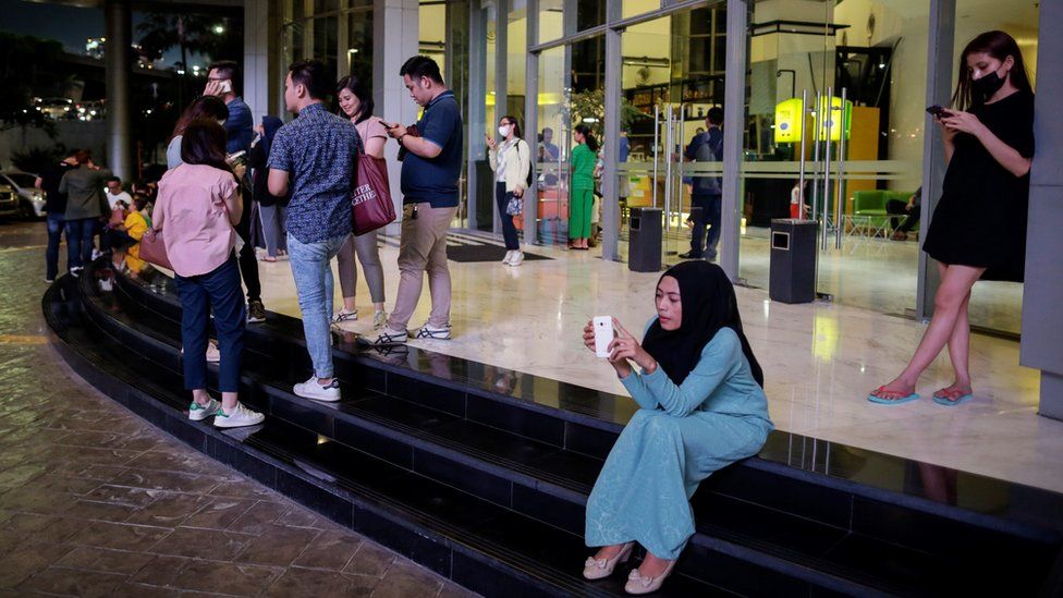 Residents stand outside an apartment block after a strong earthquake hit the area around Jakarta on August 2, 2019