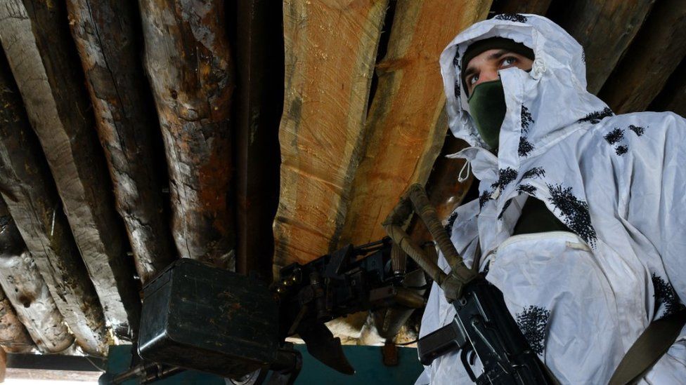 Ukrainian army soldier standing next to a machine gun at the defence line in Verkhnotoretske village that is situated on the very frontline between Ukraine and DPR armies positions