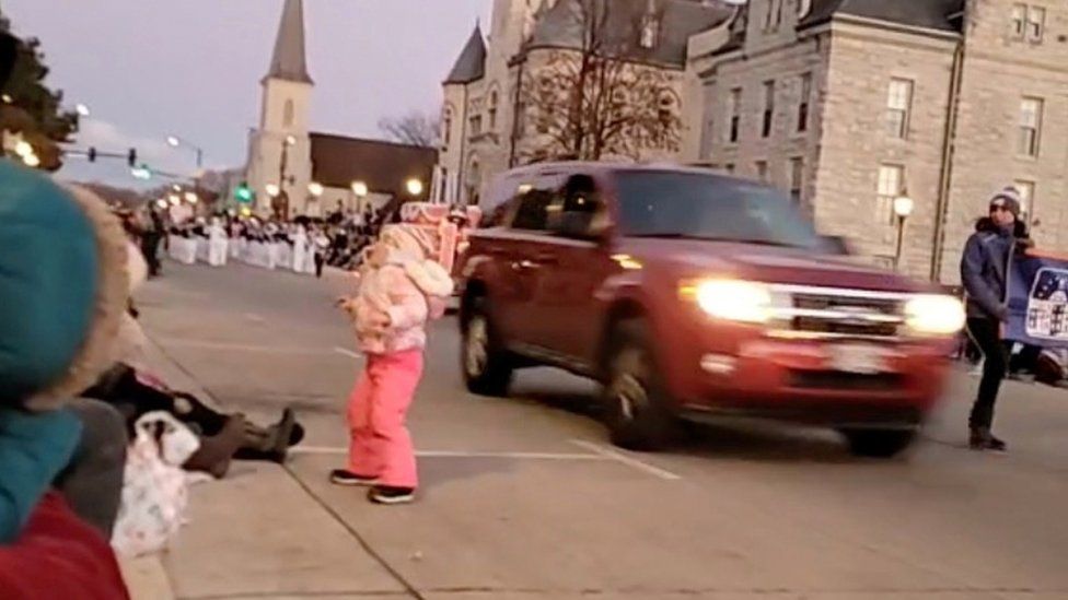 An SUV speeds past moments before plowing into a crowd of people during a Christmas parade in Waukesha, Wisconsin, U.S., in this still image taken from a November 21, 2021 social media video.