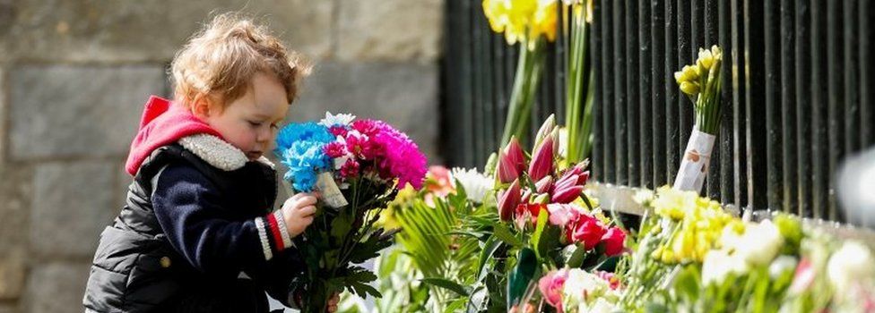 A child holds a bouquet of flowers outside Windsor Castle
