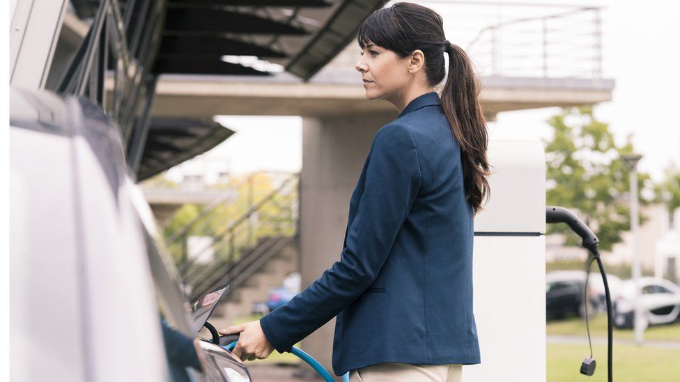 woman charging car side profile