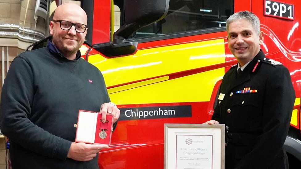 Neil Luton getting his award from the chief fire officer