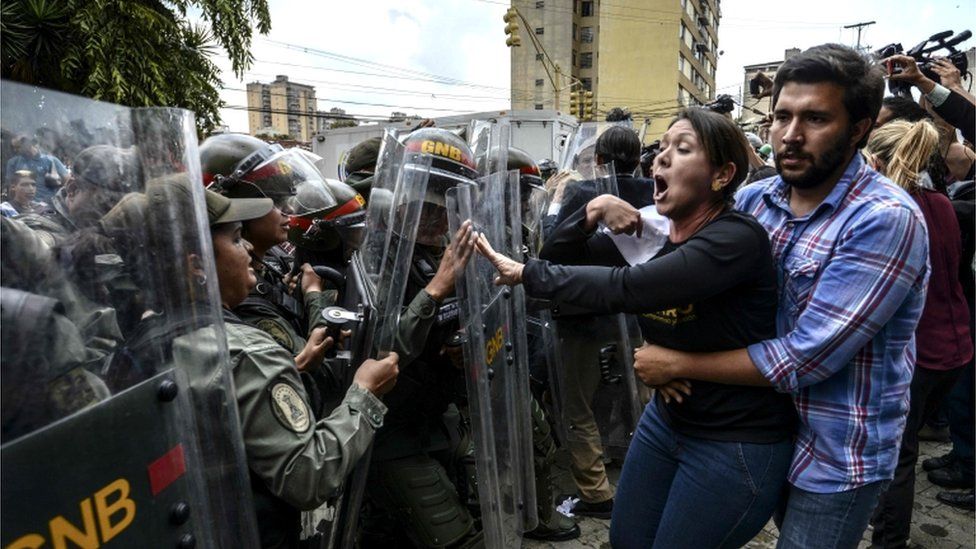 Venezuelan opposition deputy Amelia Belisario (C) argues with National Guard personnel in riot gear during a protest in front of the Supreme Court in Caracas on March 30, 2017.