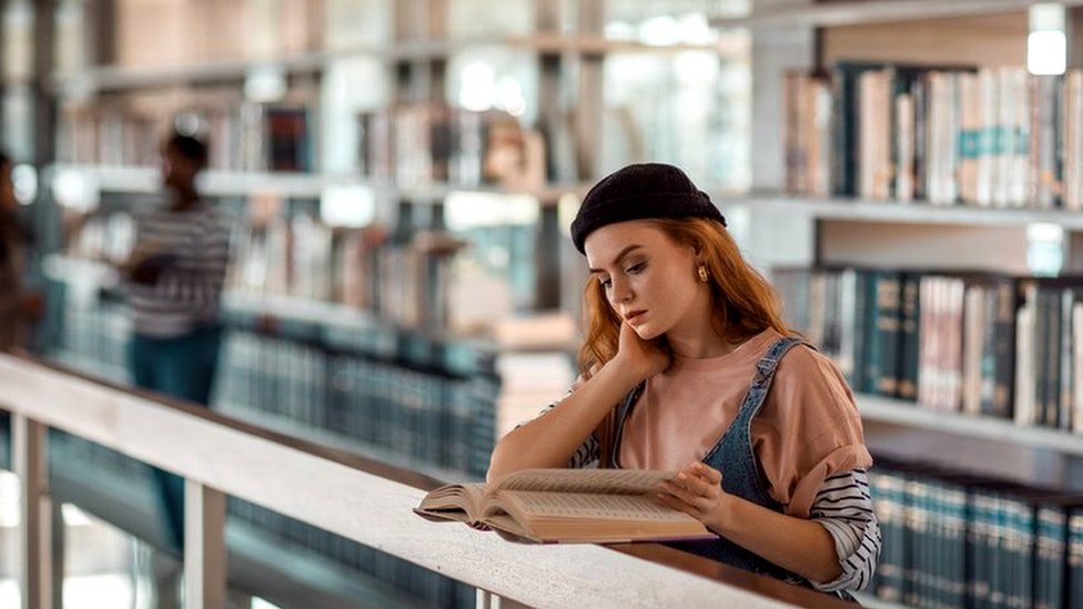 Woman reading in a library or university