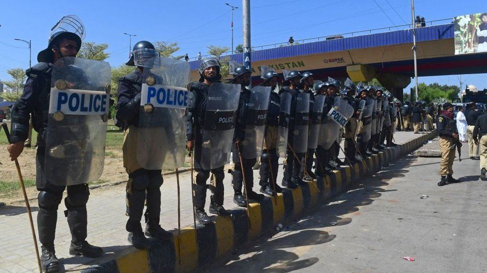 Policemen stand guard along a roadside in Karachi on May 10, 2023