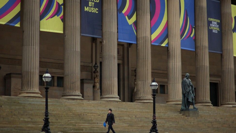 A man walks past a banner advertising Eurovision outside St George's Hall