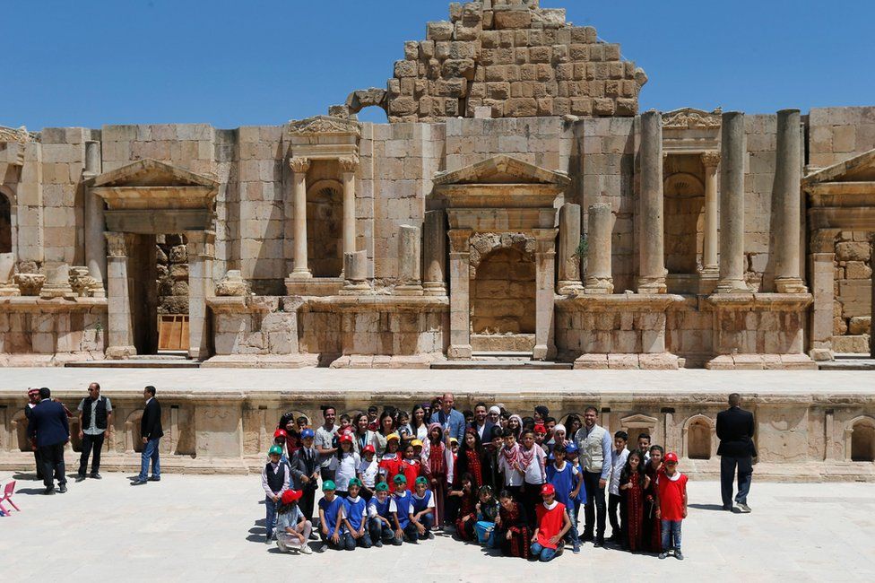 Prince William stands with Jordan's Crown Prince Hussein as they pose with people at the ancient city of Jerash, Jordan.