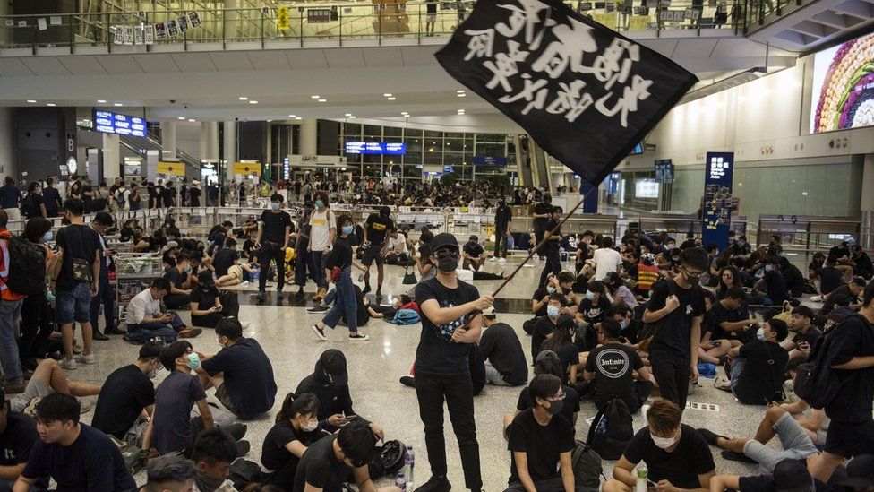 A protester waves a black flag at the Hong Kong International Airport during an anti-government protest.