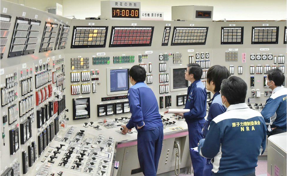 Employees of the Takahama nuclear power plant monitor instruments at its operation room