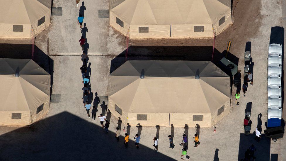 Immigrant children are led by staff in single file between tents at a detention facility next to the Mexican border in Tornillo, Texas, U.S., June 18, 2018.