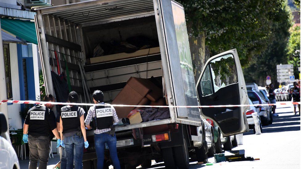 French police officers search a truck in a street of Nice on 15 July 2016, near the building where the man who drove a truck into a crowd watching a fireworks display the day before reportedly lived.