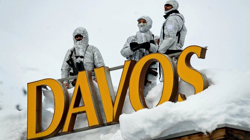 Вооруженные сотрудники службы безопасности охраняют крышу отеля, рядом с буквами «Давос»