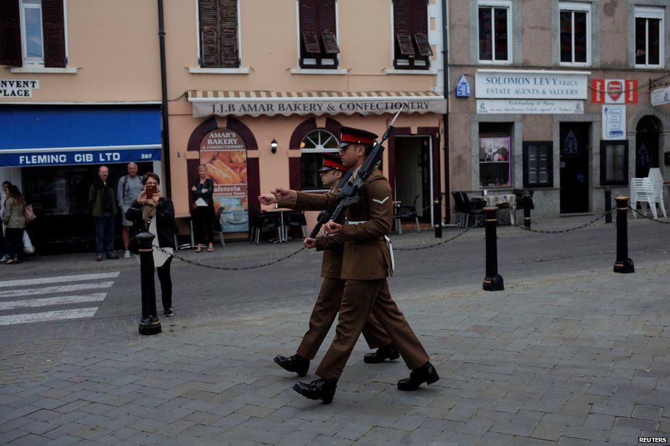 Soldiers walk during a change of guard outside the Convent building in Gibraltar