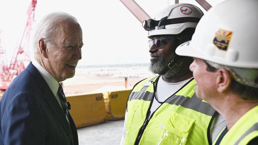 Президент США Джо Байден приветствует рабочих во время посещения завода по производству полупроводников TSMC в Фениксе, штат Аризона.