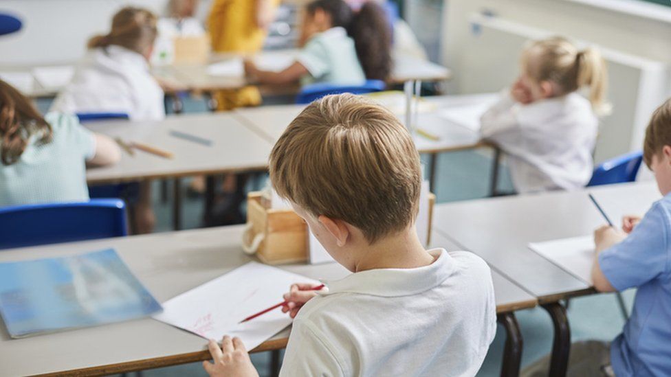 Children sat at desks in a school - stock image
