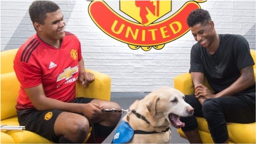Manchester United's Marcus Rashford meets 15-year-old blind footballer Rainbow and his guide dog, Drake.