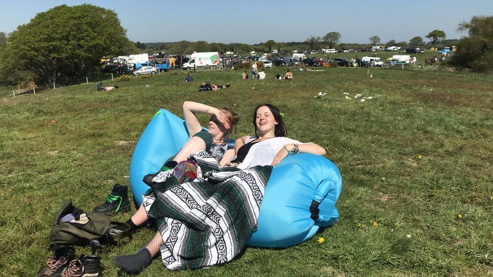 Revellers at the rave near Corfe Castle relaxing in the sunshine