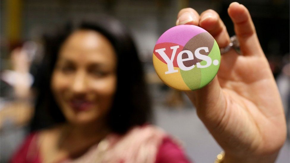 Woman holding Yes campaign badge