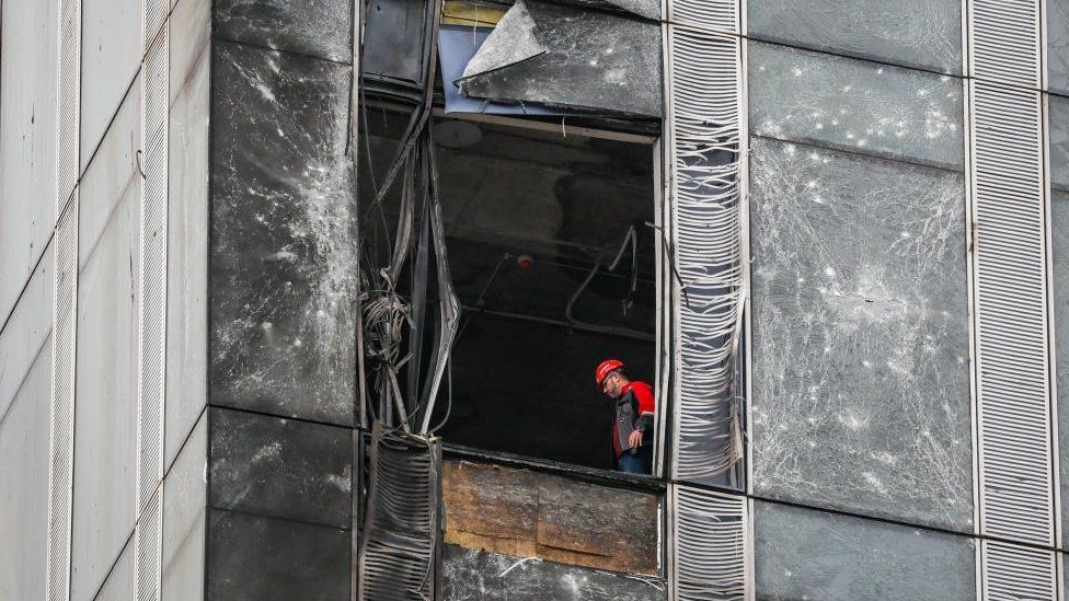 A worker inside a damaged building in the Moscow-City business center after a drone reportedly fell, in Moscow, Russia, 23 August 2023