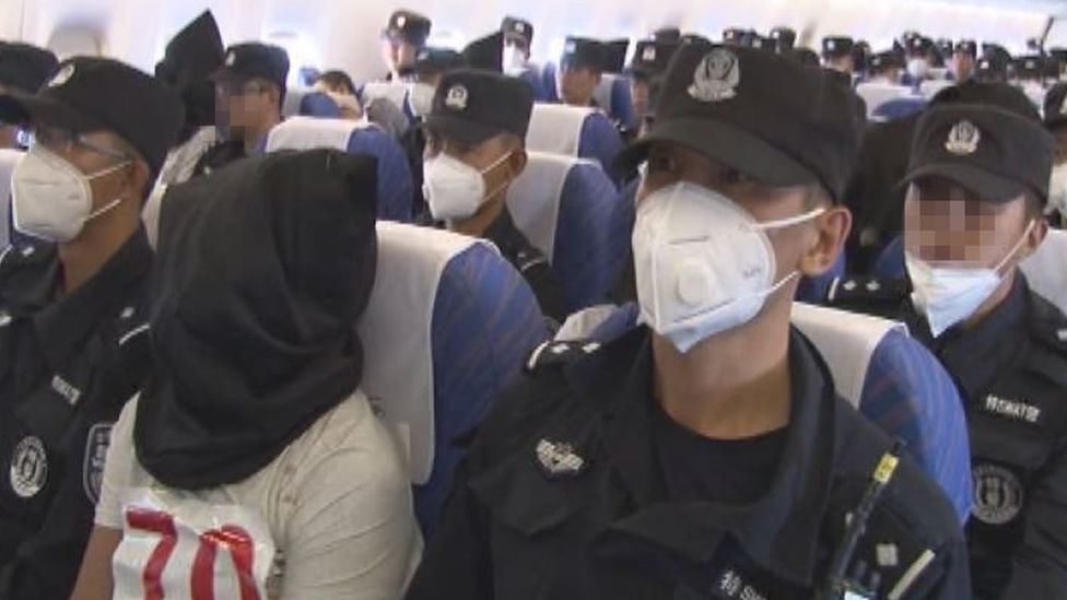 Uiguren auf dem Flug nach China nach ihrer Rückführung durch Thailand