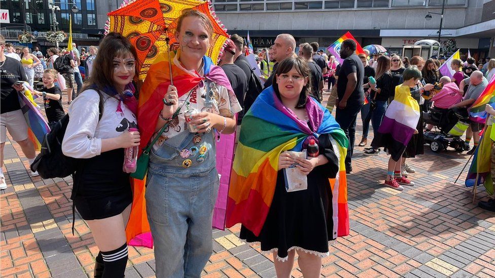 Three people wearing bright colours at the Pride event
