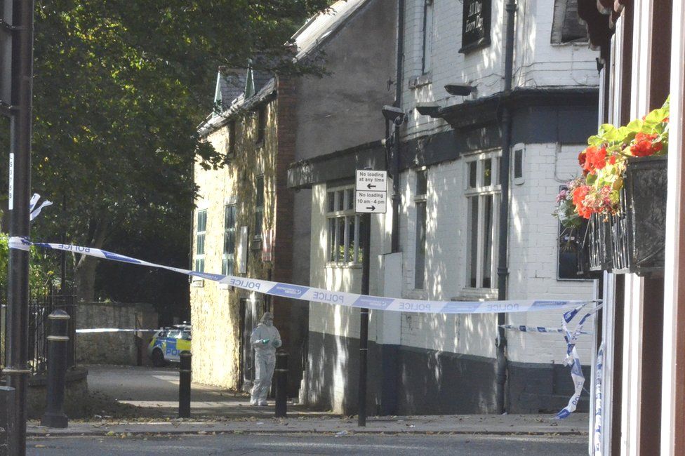 A forensics officer outside the pub