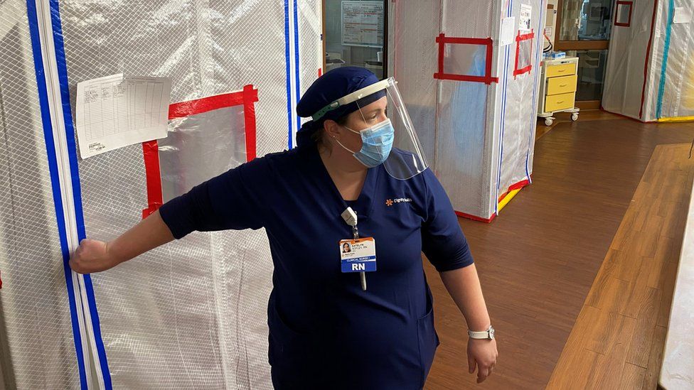 Nurse Katelyn Sofley stands at the entrance to a negative pressure ICU hospital room, where Covid-19 patients are treated, at St John's Regional Medical Center in Oxnard, California, 9 July