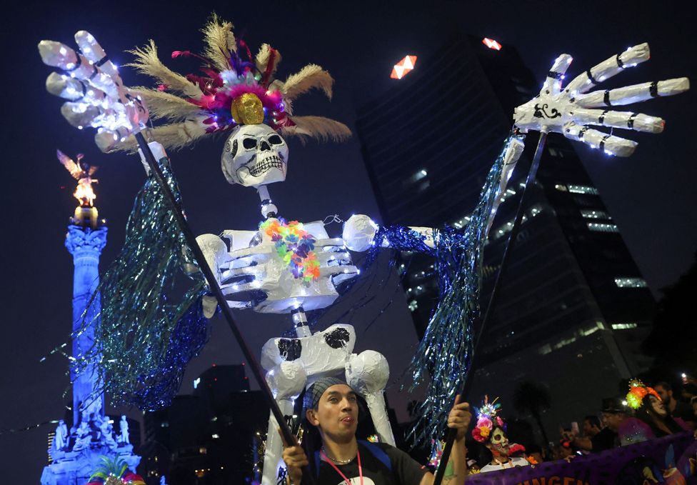 A participant performs during a parade, as part of the Day of the Dead celebrations, in Mexico City, Mexico 22 October, 2023