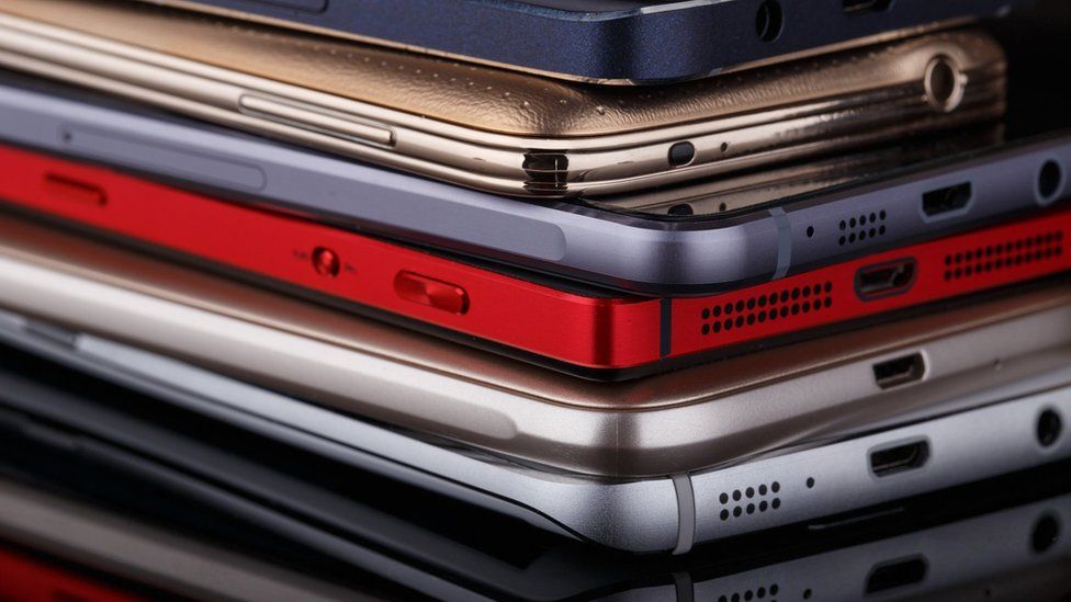 A stack of smartphones in various colours