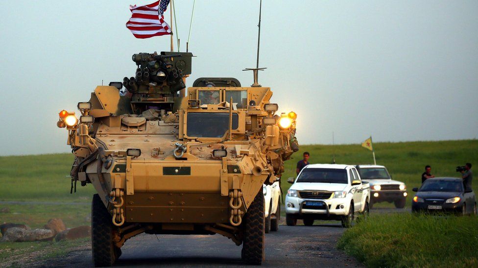 US forces, accompanied by YPG fighters, drive an armoured vehicle in northern Syria (19 December 2018)