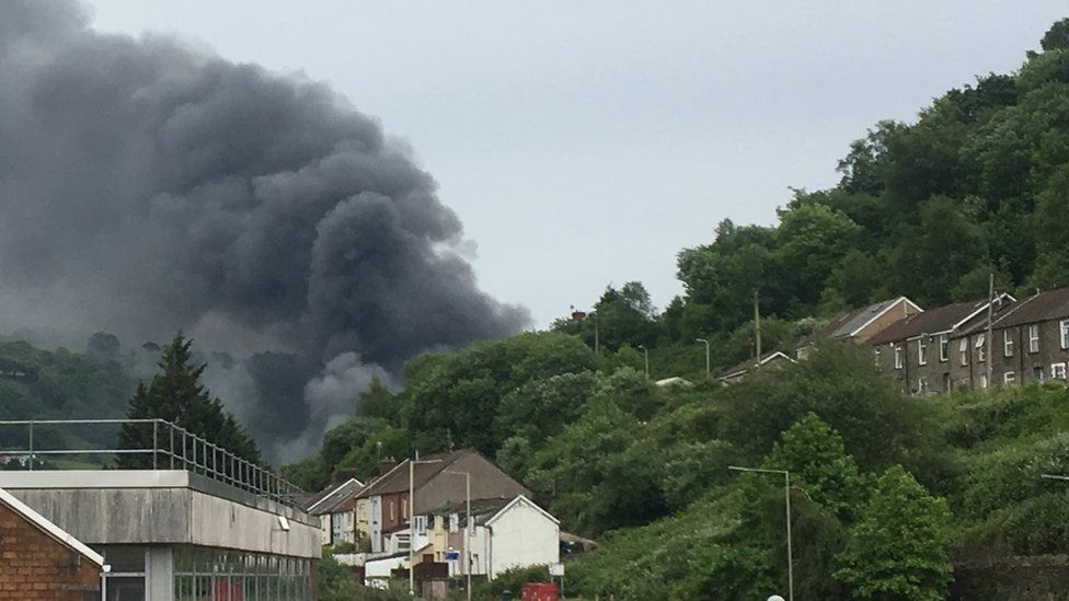 Large plumes of smoke billowing from the hillside