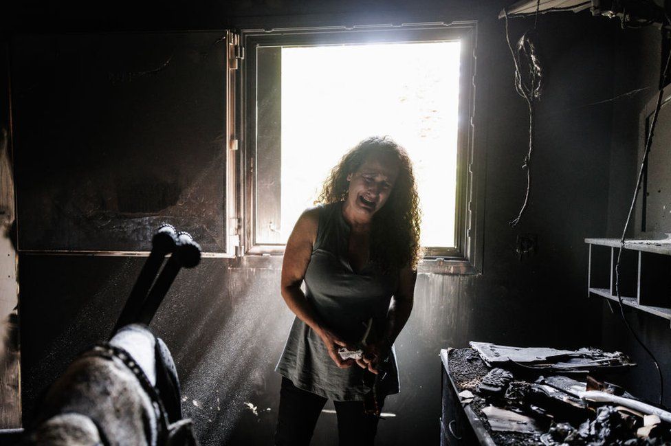 Banorja e Kibbutz Nir Oz, Hadas Kalderon, fëmijët e të cilit u morën peng dhe nëna dhe mbesa e saj u vranë, shpërthen në lot ndërsa shikon shtëpinë e djegur të nënës së saj të ndjerë Rina Sutzkever më 30 tetor 2023 në Kibbutz Nir Oz, Izrael.