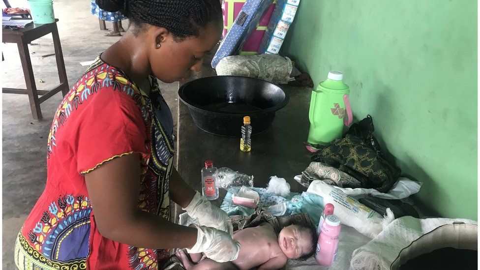 A woman tending to a new-born baby