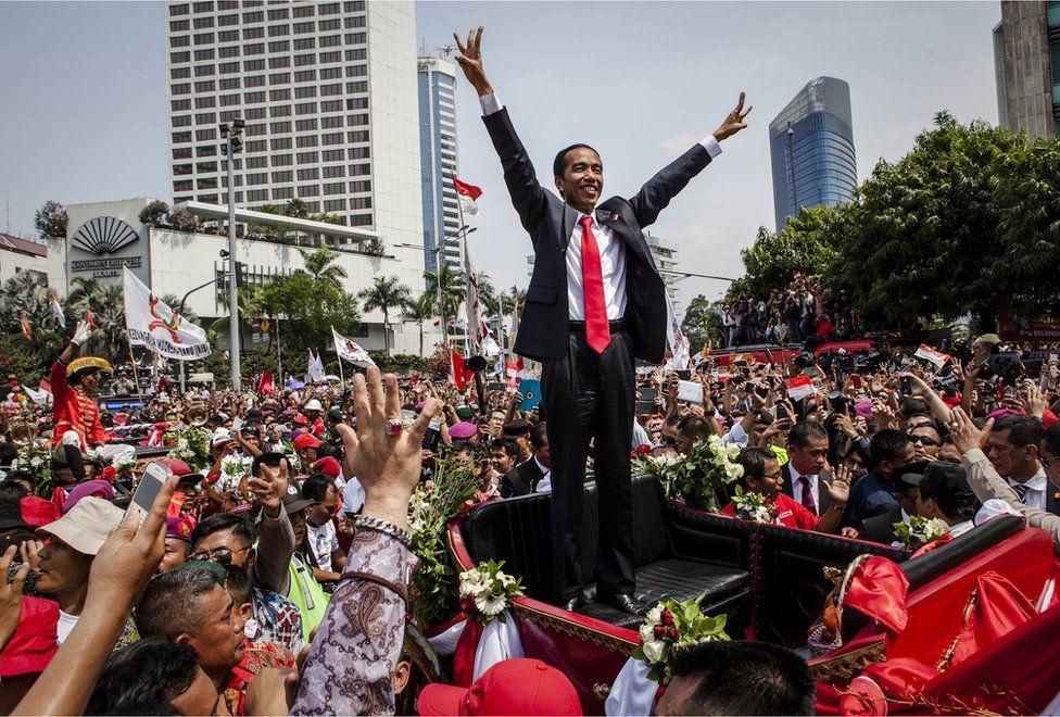 Indonesian President Joko Widodo waves to the crowd while on his journey to Presidential Palace by carriage during the ceremonial parade on 20 October 2014 in Jakarta, Indonesia.