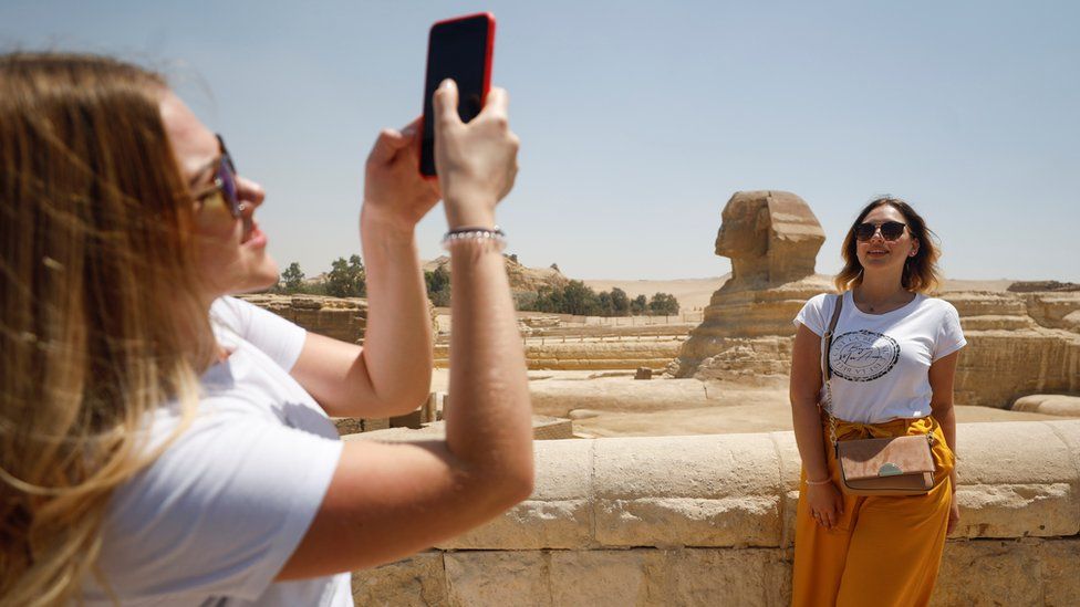 A woman poses for a photo near the Sphinx in Giza, Egypt (1 July 2020)