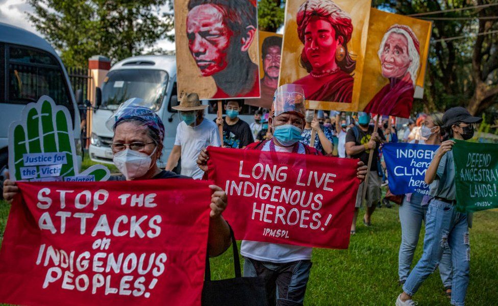 Климатические активисты держат плакаты рядом с портретами убитых филиппинских защитников окружающей среды, принимая участие в акции протеста Всемирного дня действий за климатическую справедливость 6 ноября 2021 года в Кесон-сити, Метро Манила, Филиппины.